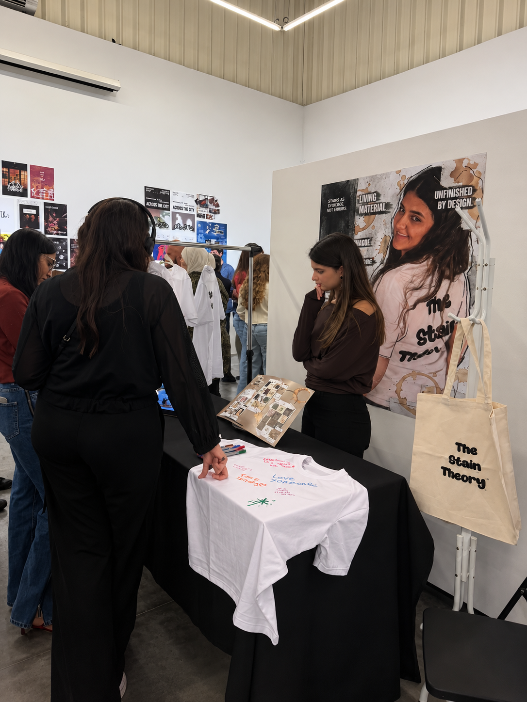 Leya Awad — The Stain Theory exhibition booth with visitors